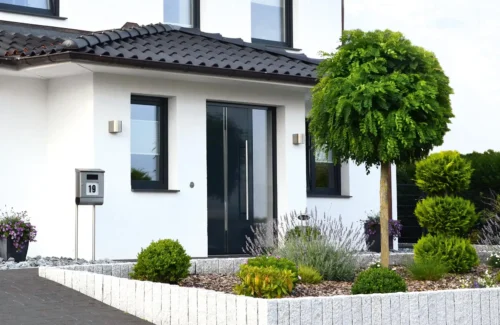 Hauseingangsbereich mit schwarzer Haustüre und Glaseinsatz daneben