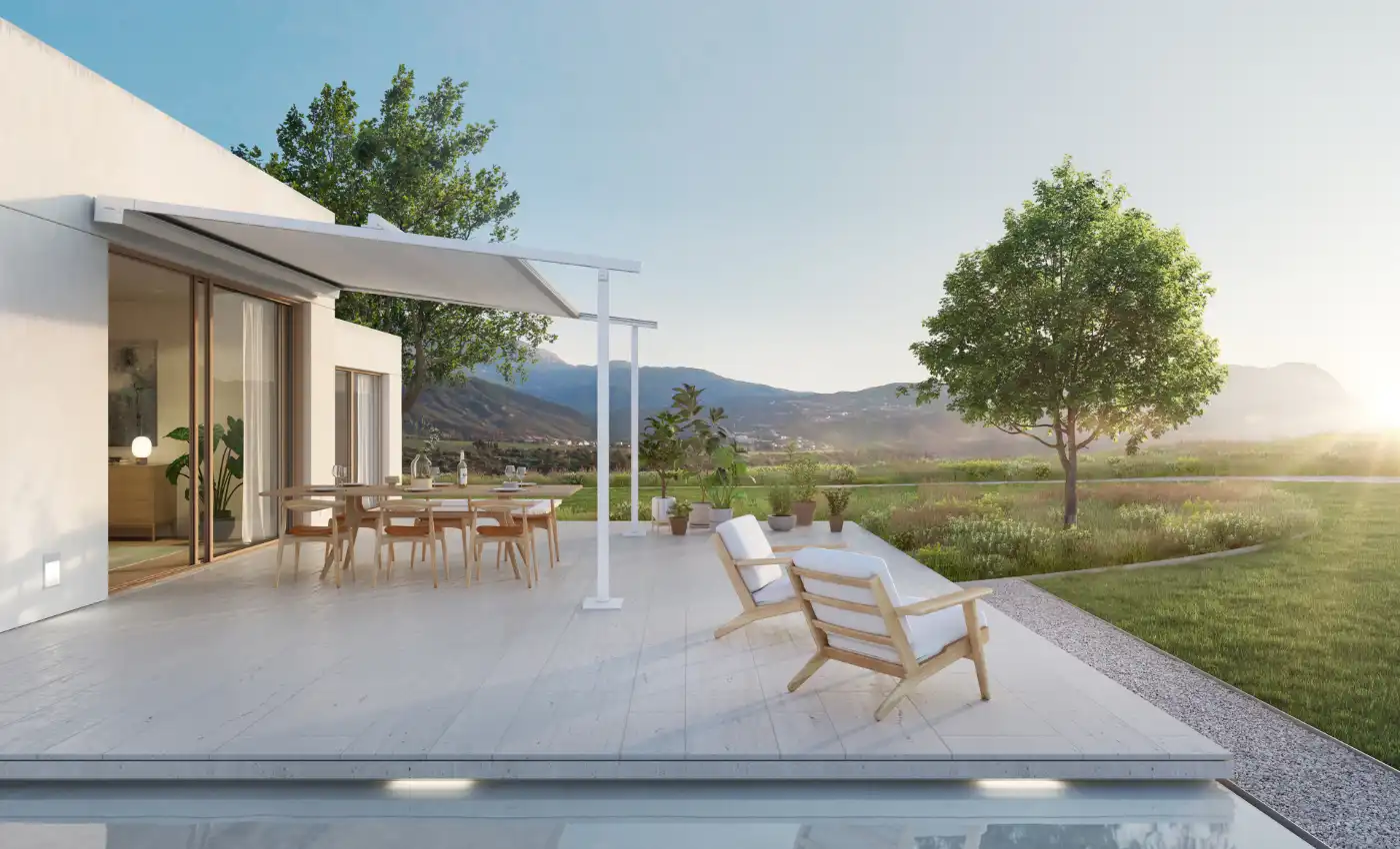 Blick über die Terrasse mit Markise in die grüne Landschaft.